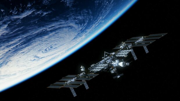 The space station orbits Earth with solar panels extended against the dark sky, 4K Desktop Wallpaper