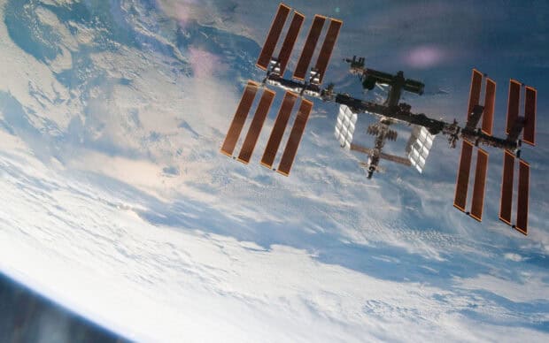 The space station orbits above the clouds and oceans of Earth, 2K Desktop Wallpaper