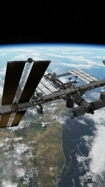 The space station is orbiting Earth with its solar panels extended visible against planet and space, HD Phone Wallpaper