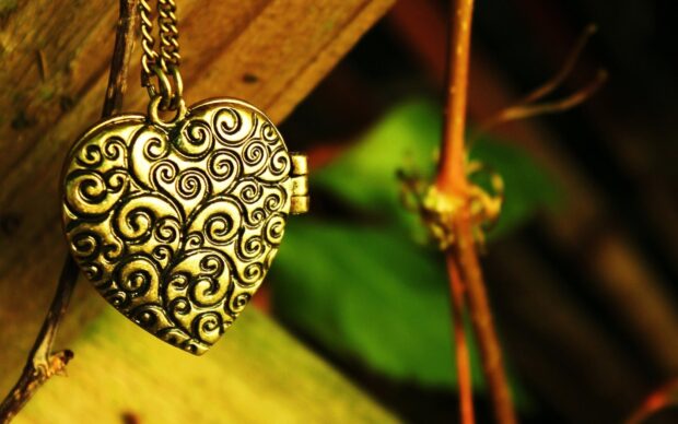 A detailed heart shaped pendant with swirling patterns on a gold necklace, HD Desktop Wallpaper