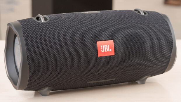 A close up view of a JBL portable speaker with a textured black surface and red logo, 4K Desktop Wallpaper