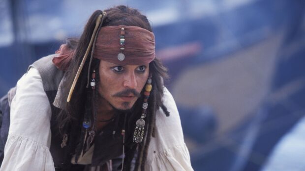A focused pirate character wears a decorated headband and beads in his hair in this Gore Verbinski scene, 4K Desktop Wallpaper