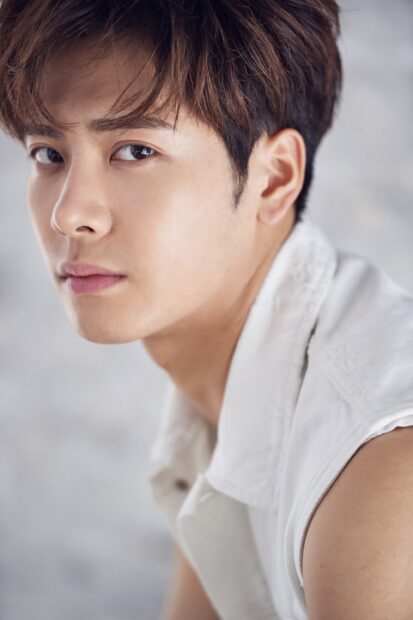 A close up portrait of Jackson Wang with intense eyes and a white sleeveless jacket, 2K Phone Wallpaper