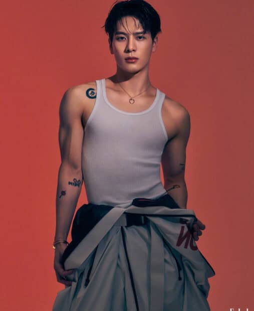 Jackson Wang stands confidently wearing a white tank top with tattoos visible on his arms, HD Mobile Wallpaper
