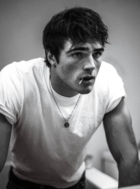 Jacob Elordi is leaning forward with a lollipop in his mouth in this black and white portrait, 2K Mobile Wallpaper