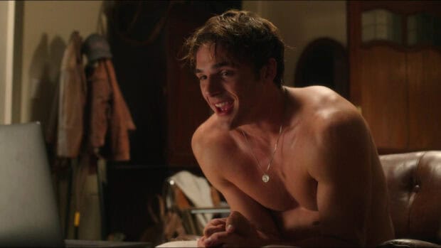 Jacob Elordi smiles warmly while sitting shirtless in a cozy room setting, HD Desktop Wallpaper