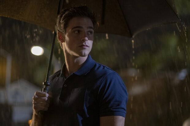 Jacob Elordi is holding an umbrella while standing in the rain at night, HD Desktop Wallpaper