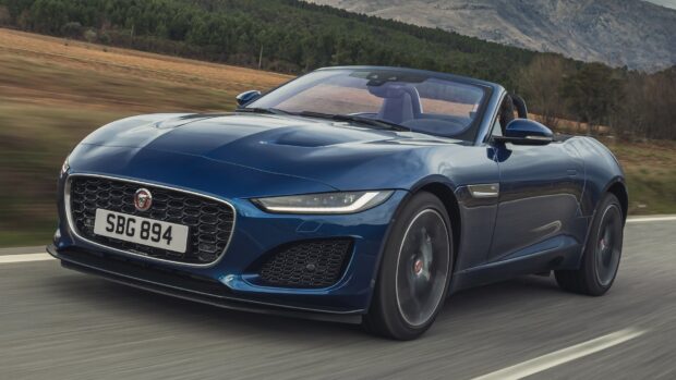 A blue Jaguar F Type sports car is driving fast along a rural road with trees and hills in the background, HD Desktop Wallpaper