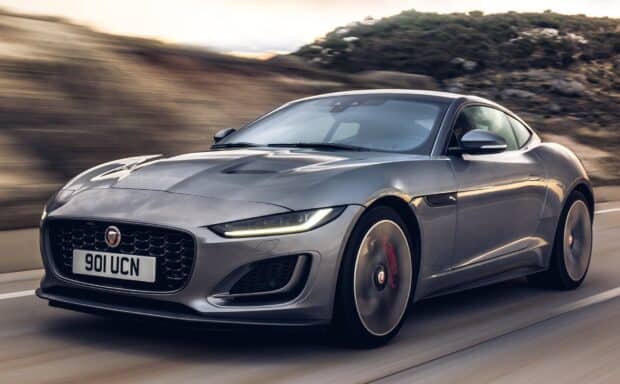 A sleek Jaguar F Type drives along a winding road with mountains in the background, HD Desktop Wallpaper