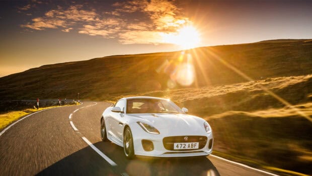 A white Jaguar F Type drives along a winding road under a bright sunlit sky, HD Desktop Wallpaper