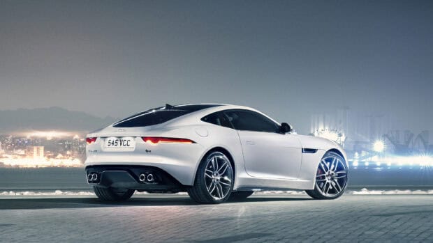 A white Jaguar F Type is parked on a paved surface with city lights in the background, HD Desktop Wallpaper