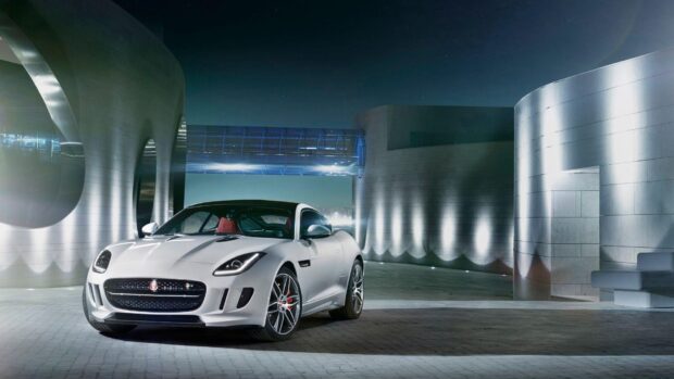 A white Jaguar F Type is parked near sleek metallic buildings at night, HD Desktop Wallpaper