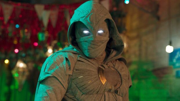 Jake Lockley is shown wearing a detailed cloak with glowing eyes in a vibrant setting, HD Desktop Wallpaper