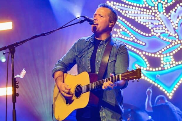 Jason Isbell is playing guitar and singing on stage during a live concert, HD Desktop Wallpaper