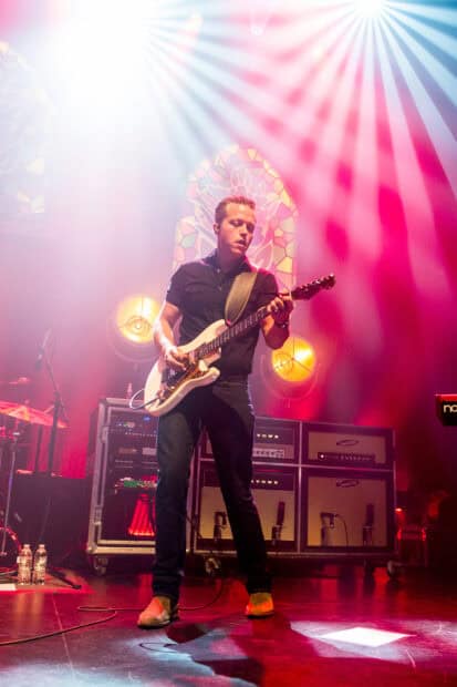 Jason Isbell performing live on stage with guitar and bright lights, HD Mobile Wallpaper
