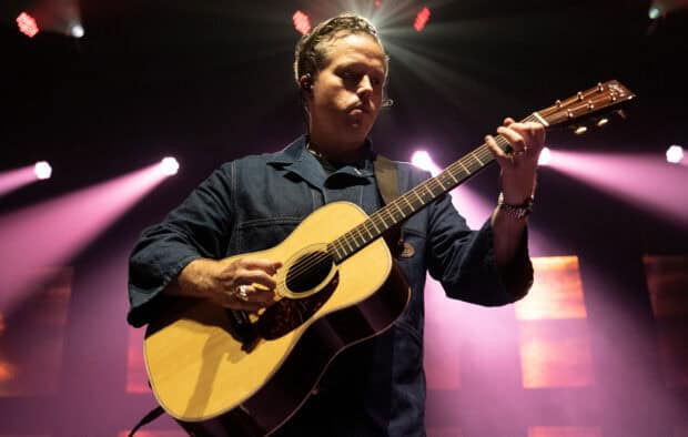 Jason Isbell is performing live playing an acoustic guitar under stage lights, HD Desktop Wallpaper