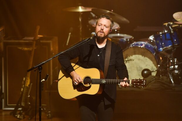 Jason Isbell is performing live with a guitar in a concert setting, HD Desktop Wallpaper