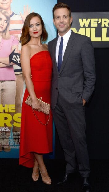 Jason Sudeikis stands next to an actress dressed in a red dress at a movie premiere, 2K Mobile Wallpaper