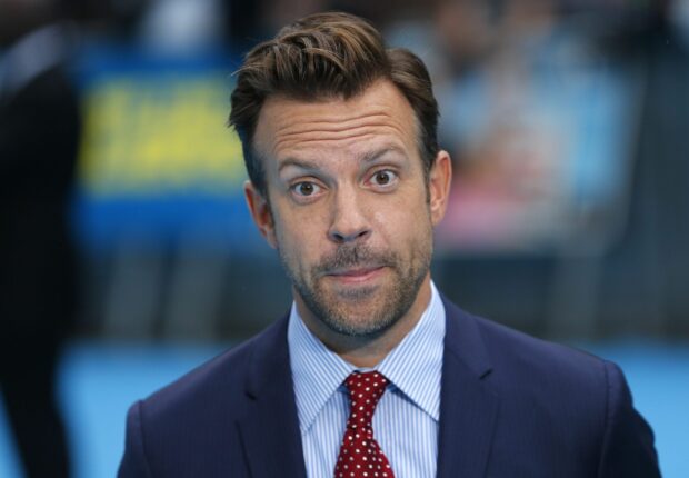 Jason Sudeikis smiles wearing a blue suit and red polka dot tie at an event, 2K Desktop Wallpaper