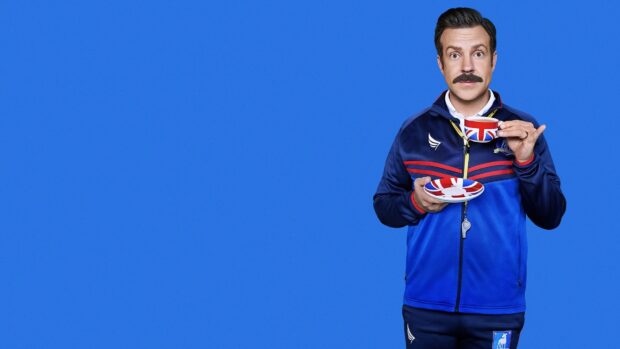 Jason Sudeikis is holding a teacup and saucer with the British flag on a blue background, HD Desktop Wallpaper