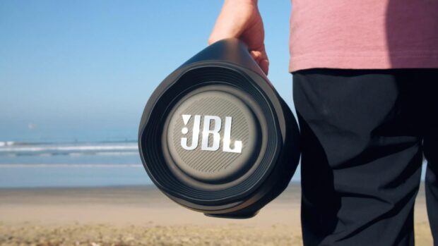 A person is holding a JBL speaker near the beach on a sunny day, HD Desktop Wallpaper