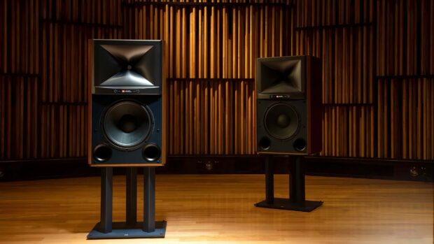 Two Jbl speakers are placed on black stands in a room with wooden floors and walls, 2K Desktop Wallpaper