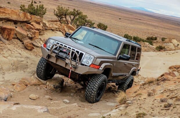 A Jeep Commander is navigating off road rocks and dirt in a desert, HD Desktop Wallpaper