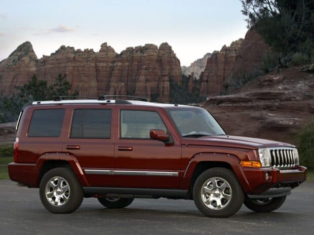 A red Jeep Commander is parked with rocky mountains in the background, HD Desktop Wallpaper