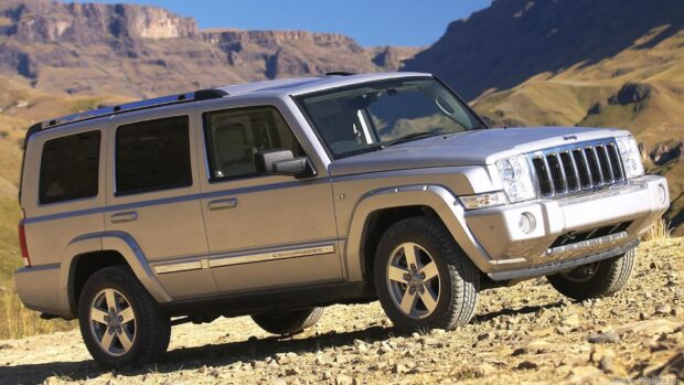 A Jeep Commander driving over rocky terrain with mountains in the background, HD Desktop Wallpaper