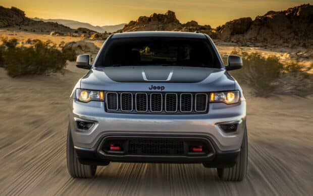 A Jeep Grand Cherokee is driving on a sandy desert road at sunset, HD Desktop Wallpaper