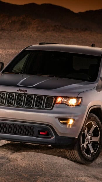 A Jeep Grand Cherokee is parked on rocky terrain under a dusky sky, HD Mobile Wallpaper