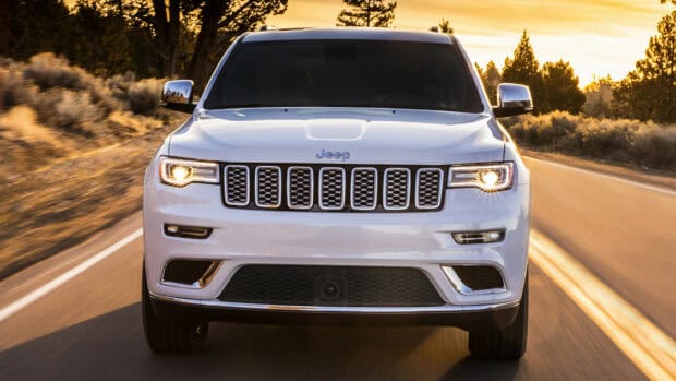 A white Jeep Grand Cherokee drives on a road during sunset with its headlights on, HD Desktop Wallpaper