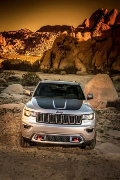 A silver Jeep Grand Cherokee is parked in a rocky desert landscape during sunset, HD Mobile Wallpaper