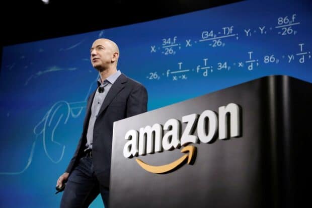Jeff Bezos is delivering a speech with mathematical formulas displayed in the background related to Amazon, HD Desktop Wallpaper