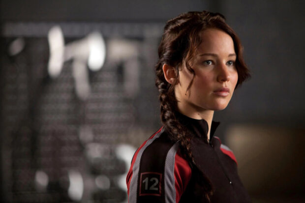 Jennifer Lawrence in a training outfit from The Hunger Games stands focused, 2K Desktop Wallpaper