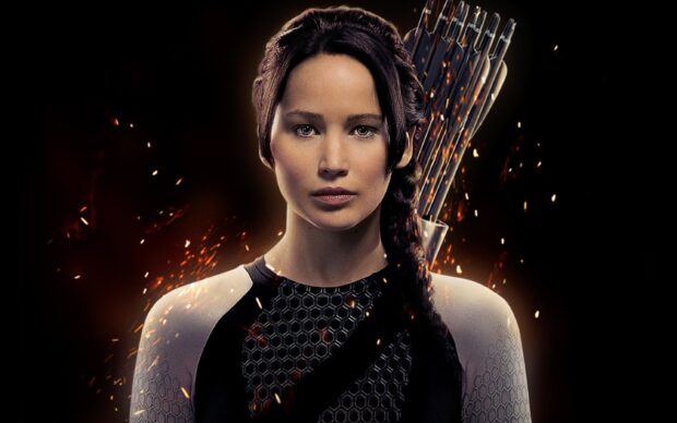 Jennifer Lawrence in The Hunger Games wears a black and white outfit with a quiver of arrows behind her, 2K PC Wallpaper