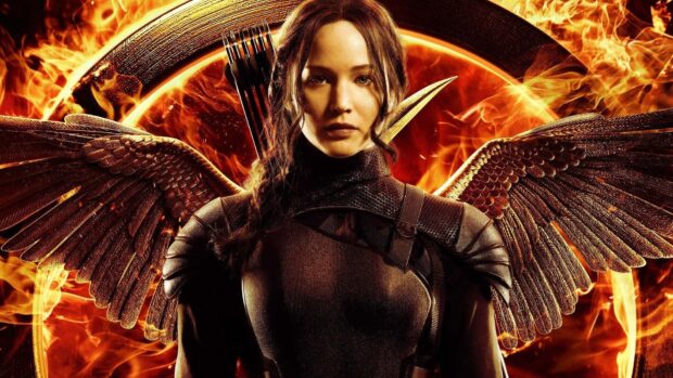 Jennifer Lawrence stands in front of a flaming emblem with wings on her back, HD Desktop Wallpaper