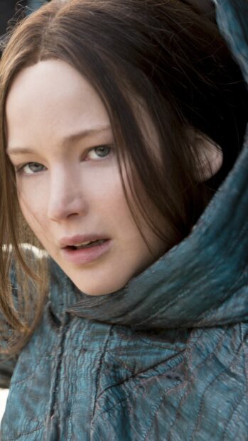 Jennifer Lawrence from The Hunger Games wears a blue hooded outfit and looks intensely ahead, 4K Mobile Wallpaper