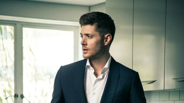 Jensen Ackles is standing indoors wearing a navy suit and white shirt, HD Desktop Wallpaper