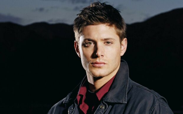 Jensen Ackles stands wearing a dark jacket and red shirt with a serious expression, HD Desktop Wallpaper