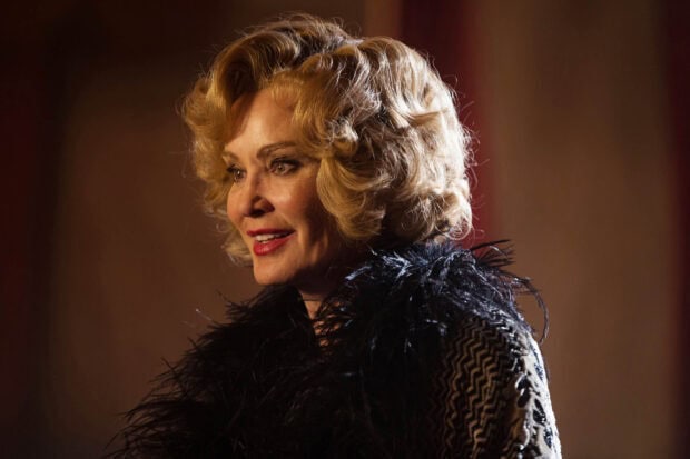 Jessica Lange wears a black feathered outfit with styled blonde hair in a close up shot, HD Desktop Wallpaper