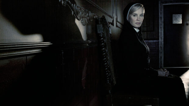 Jessica Lange sits on a wooden chair in a dimly lit room, HD Desktop Wallpaper