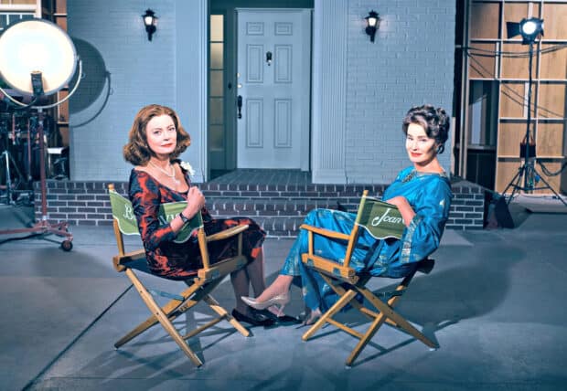 Jessica Lange and another woman sit on director chairs on set in vintage dresses, 2K Desktop Wallpaper