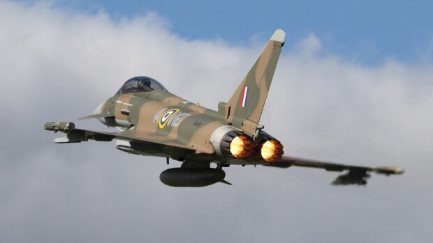 A jet fighter flies with afterburners ignited against a cloudy sky, HD Desktop Wallpaper