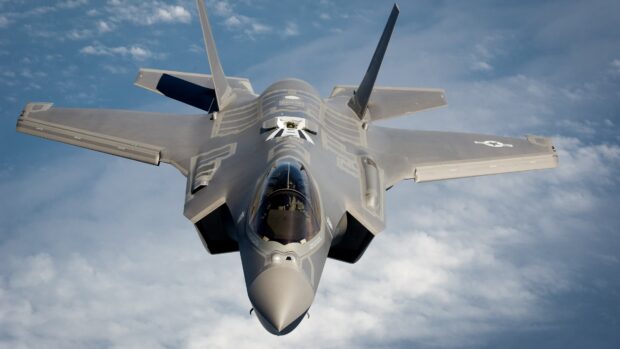 A jet fighter flies high above the clouds showcasing advanced military design, 4K Desktop Wallpaper