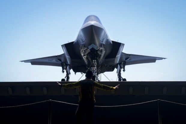 A jet fighter is inspected by a ground crew member before flight, HD Desktop Wallpaper