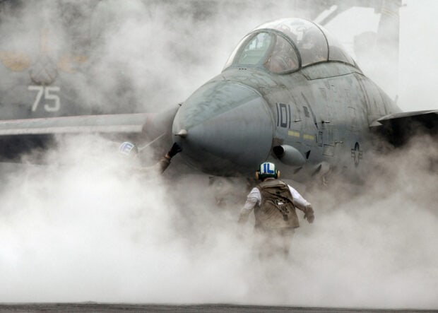 Two crew members assist a jet fighter surrounded by steam, HD Desktop Wallpaper