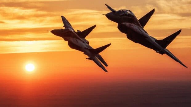 Two jet fighters are soaring through the sky at sunset with an orange horizon, HD Desktop Wallpaper