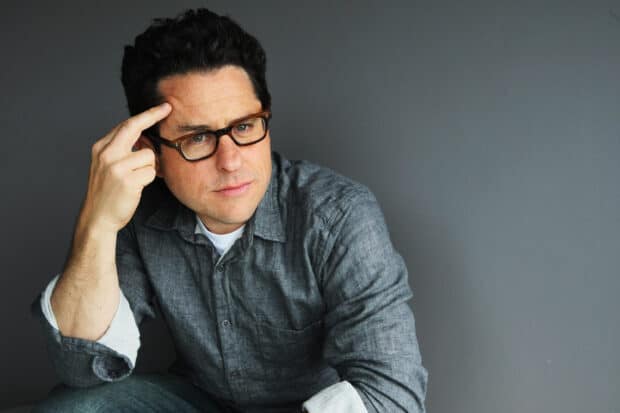 Jj Abrams is wearing glasses and a gray shirt in a thoughtful pose, 2K Desktop Wallpaper