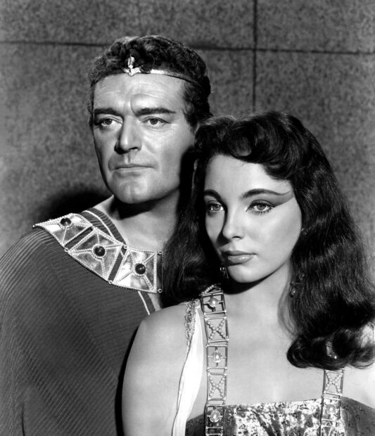 Joan Collins is seen with a male co star in a vintage film scene, HD Mobile Wallpaper